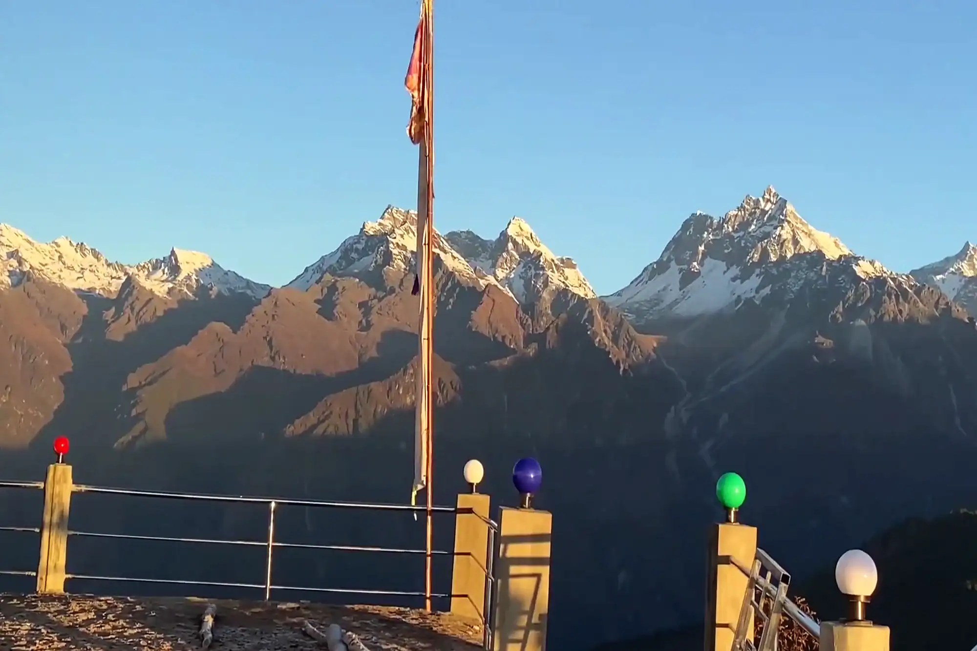 Balcony viewpoint with colorful lights overlooking snow-capped Himalayan mountain peaks at sunrise