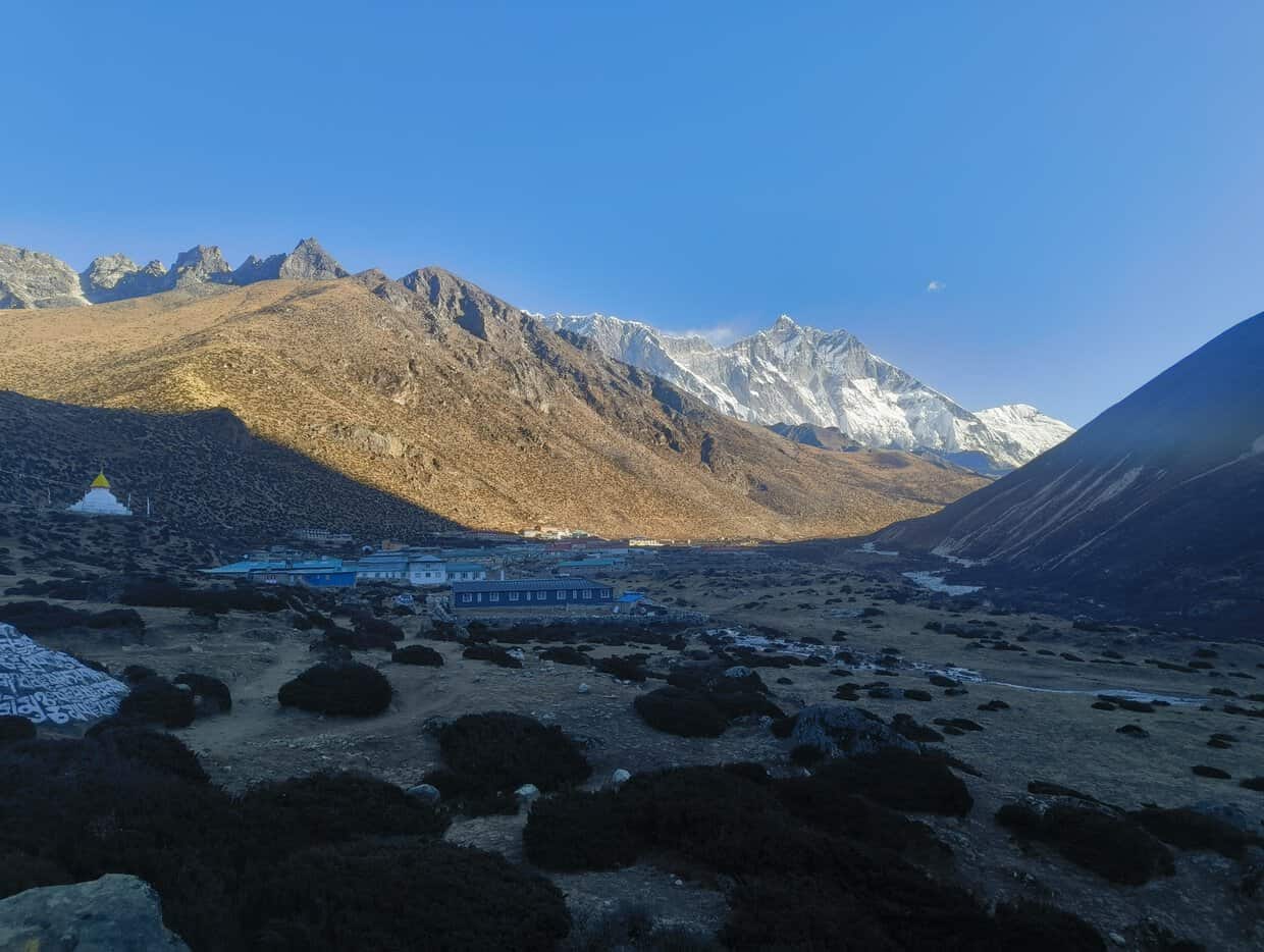 Himalayan mountain village with snow-capped peaks and blue sky in Nepal