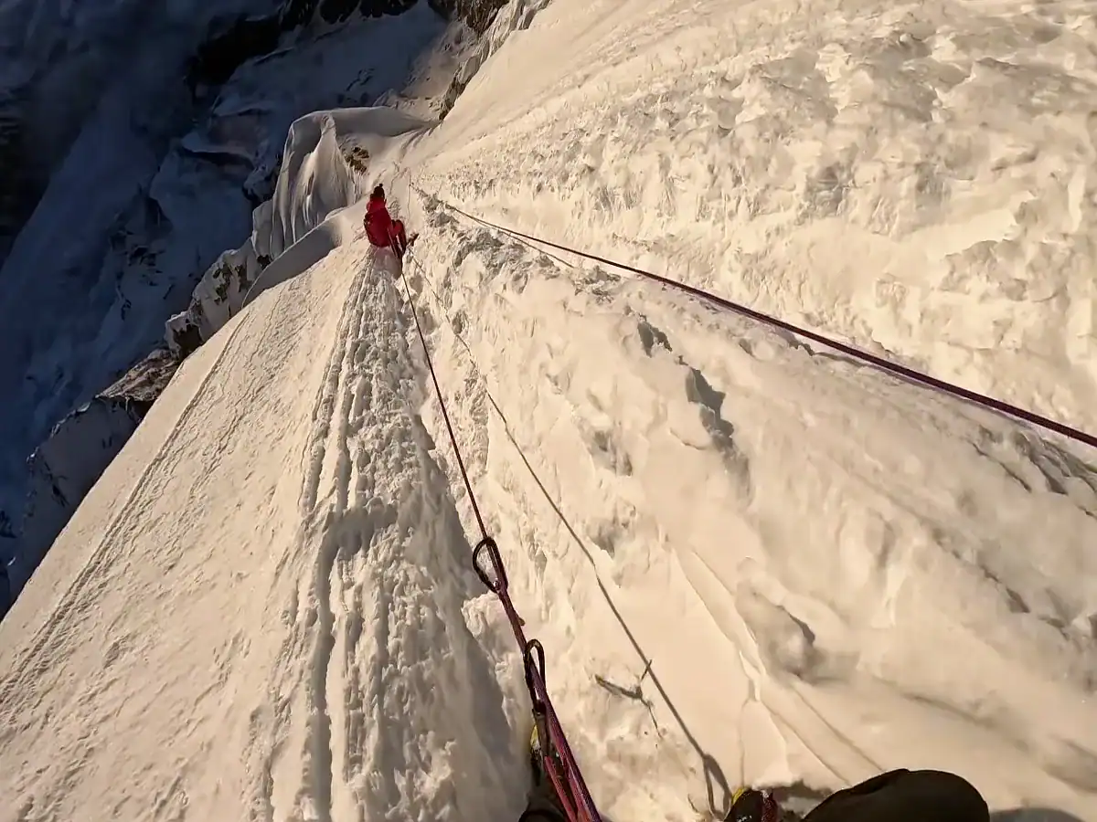climbers descending from the Ama Dablam summit on the steep snowy way.